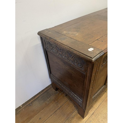 869 - An 18th century carved oak coffer, 122 cm wide