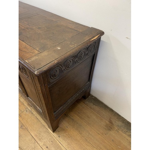 869 - An 18th century carved oak coffer, 122 cm wide