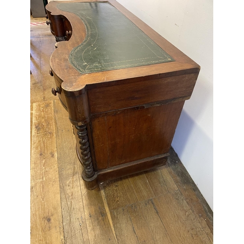 1047 - A mahogany kneehole desk, of shaped outline, having a leatherette inset top, 113 cm wide