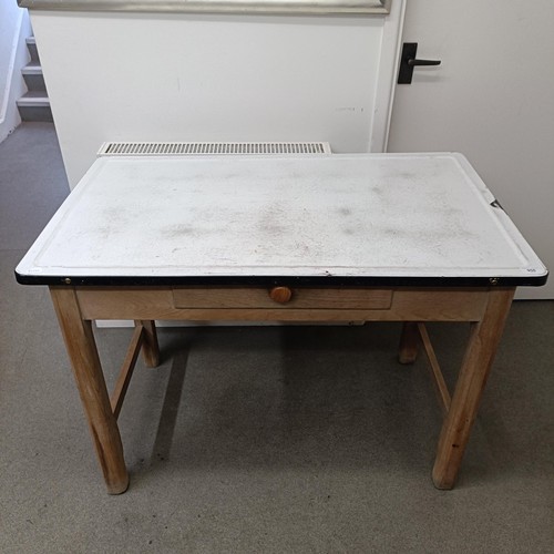 950 - A mid 20th century baking table, with an enamel and metal top, some losses, on a pine base, 107 cm w... 