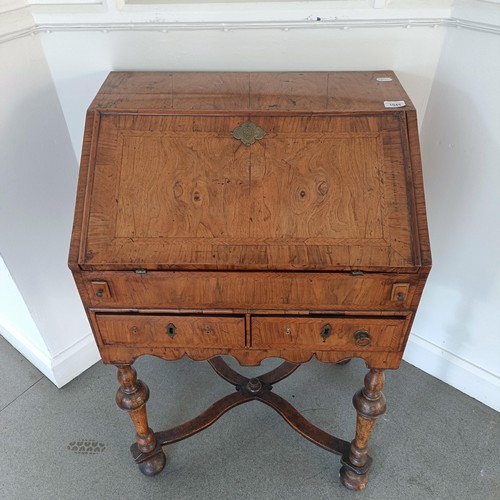 1045 - An 18th century walnut bureau, of small proportions, the hinged top to reveal drawers, pigeon holes ... 