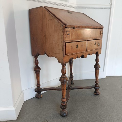 1045 - An 18th century walnut bureau, of small proportions, the hinged top to reveal drawers, pigeon holes ... 