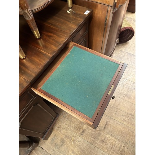 858 - An unusual mahogany kneehole desk, the top having three drawers, with cupboard doors to the side, 84... 