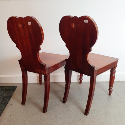 916 - A pair of 19th century mahogany hall chairs, the carved backs painted crests (2)