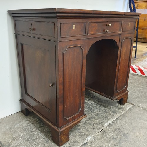 858 - An unusual mahogany kneehole desk, the top having three drawers, with cupboard doors to the side, 84... 