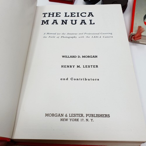 543 - A Leica pocket book, a Leica lens box, a box camera, in a vintage leather suitcase, a Leitz slide pr... 