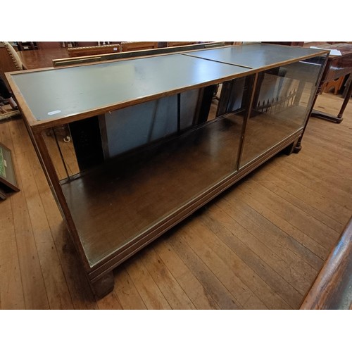 875 - An oak and glass shop display cabinet, 184 cm wide