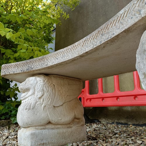 957 - A composite stone garden bench, with supports in the form of lions, 150 cm wide