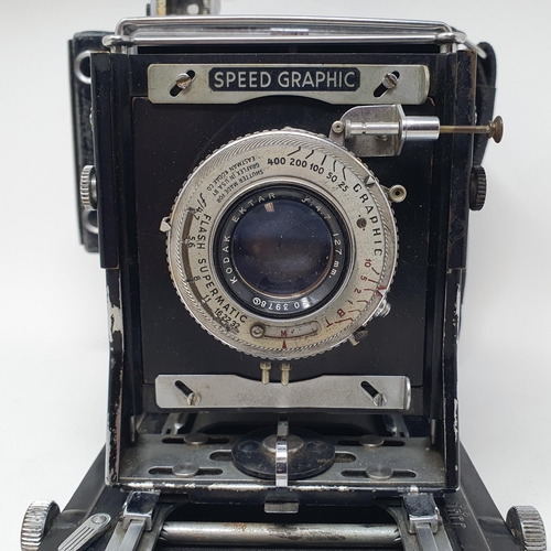 611 - A Graflex Speed Graphic bellows camera, with a Kodak lens, assorted photography equipment, a magic l... 