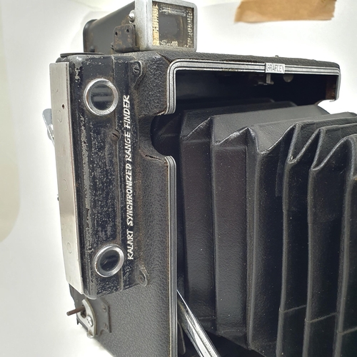 611 - A Graflex Speed Graphic bellows camera, with a Kodak lens, assorted photography equipment, a magic l... 