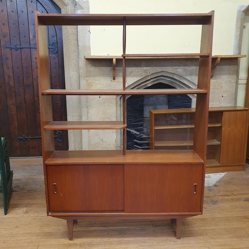 182 - A 1970s teak room divider, the top with open shelves on a base with two sliding doors on square tape... 
