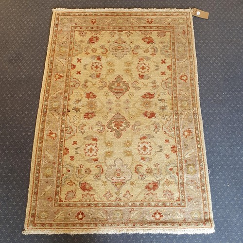 827 - An Oushak cream ground rug, 140 x 98 cm