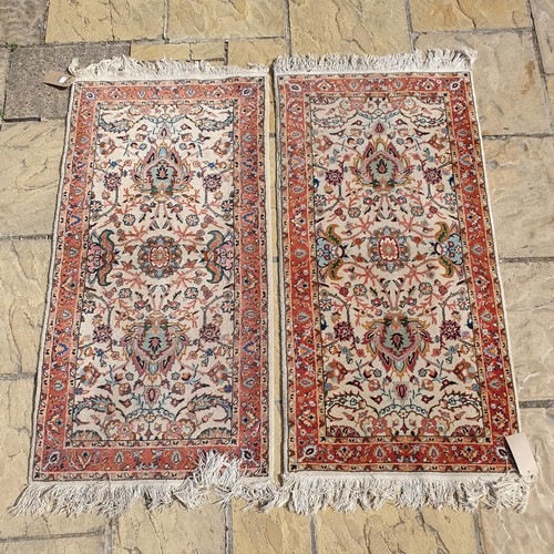 845 - A pair of Kerman cream ground mats, 140 x 70 cm (2)