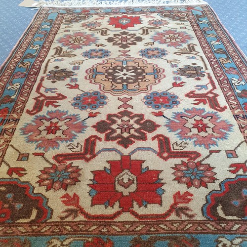 850 - A Shervin cream ground rug, 104 x 73 cm