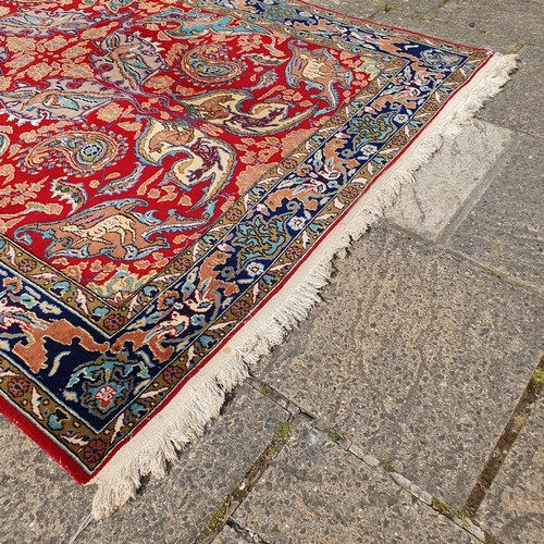 851 - A Persian Isfahan red ground rug, 215 x 153 cm