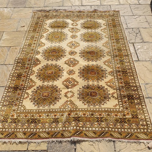 855 - An Afghan gold ground carpet, 285 x 202 cm