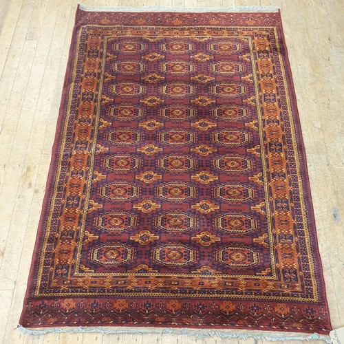 857 - An Afghan type red ground rug, 188 x 130 cm