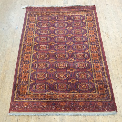 857 - An Afghan type red ground rug, 188 x 130 cm