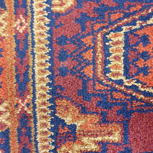 857 - An Afghan type red ground rug, 188 x 130 cm