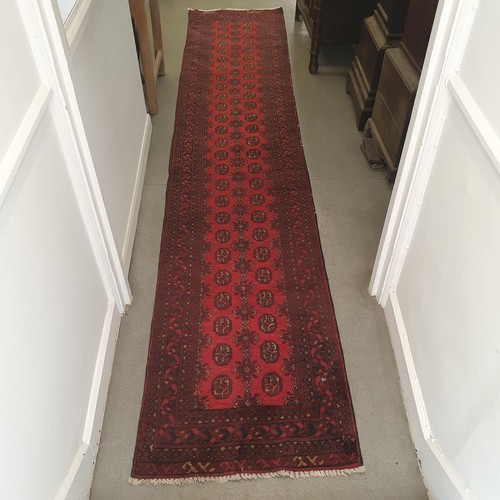 860 - An Afghan type red ground runner, 395 x 79 cm