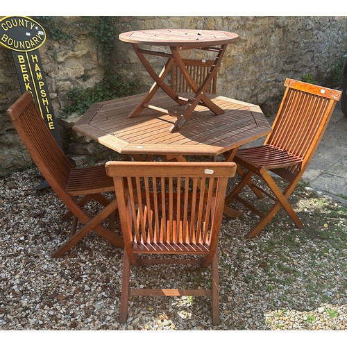 952 - A teak octagonal garden table, 116 cm wide, a teak occasional table, and four folding chairs (6)