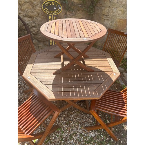 952 - A teak octagonal garden table, 116 cm wide, a teak occasional table, and four folding chairs (6)