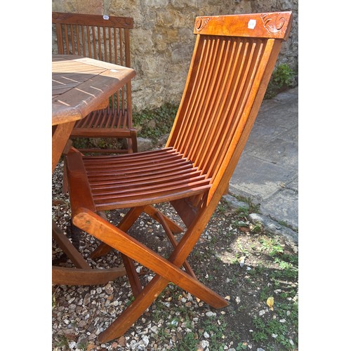 952 - A teak octagonal garden table, 116 cm wide, a teak occasional table, and four folding chairs (6)