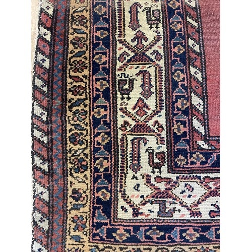 938 - A Persian red ground rug, with multiple borders, 180 x 98 cm