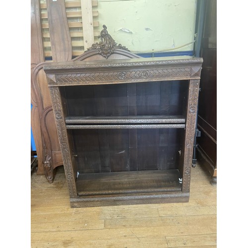 897 - A carved oak bookcase, with adjustable shelves, 103 cm wide, and three rugs (4)