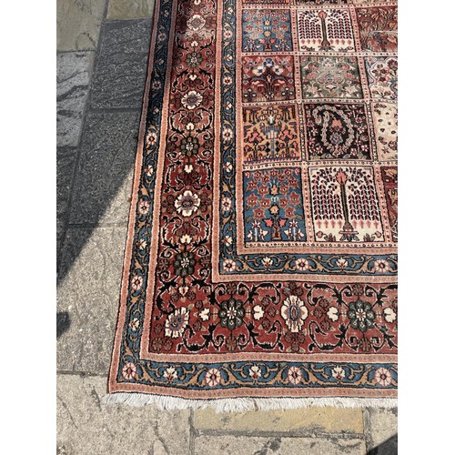 835 - A Persian red ground rug, the centre with repeating rectangular medallions, 310 x 210 cm