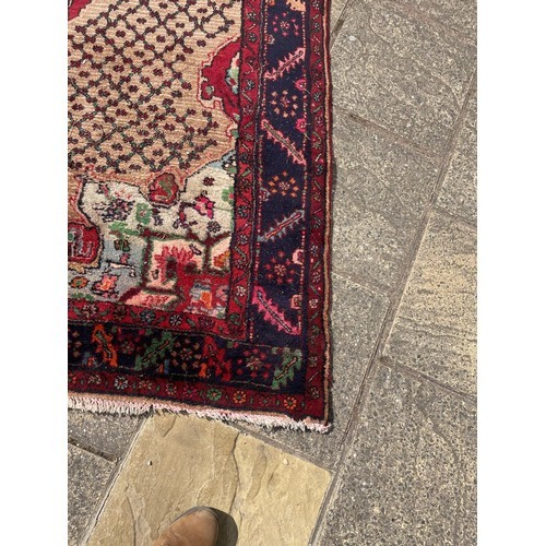 830 - A Persian cream ground rug, with a main blue border, 340 x 160 cm