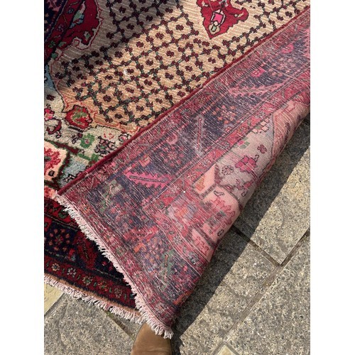 830 - A Persian cream ground rug, with a main blue border, 340 x 160 cm