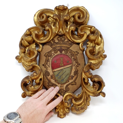 509 - An embroidered crest, in a heavily carved giltwood rococo style frame, 46 x 40 cm