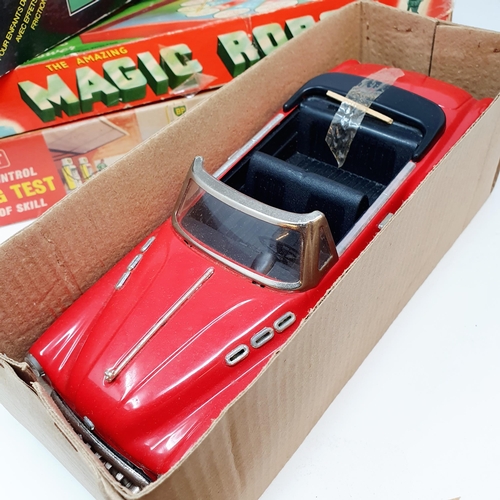 538 - A Chinese friction powered Standard Saloon convertible toy car, a Magic Robot game, and a driving te... 