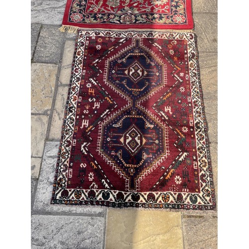 853 - A red ground Persian rug, 148 x 100 cm, and a red ground rug, 172 x 118 cm (2)