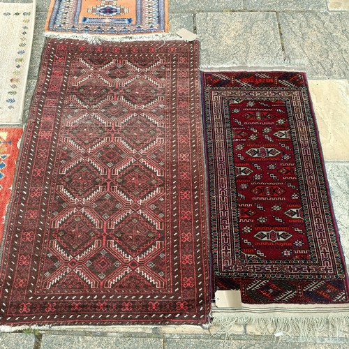 926 - A Persian red ground rug, 120 x 53 cm, a Persian red ground rug, 143 x 84 cm, and four other rugs (6... 