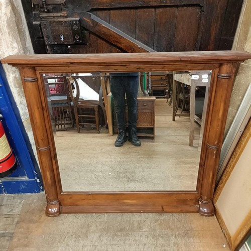 889 - A pine framed overmantel mirror, with column supports, 110 x 128 cm