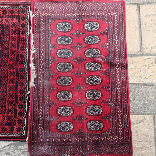 748 - A pink ground runner, 270 x 68 cm, a red ground rug, 137 x 80 cm, and another red ground rug, 214 x ... 