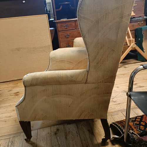 780 - A pair of wingback armchairs, on mahogany tapering legs (2)