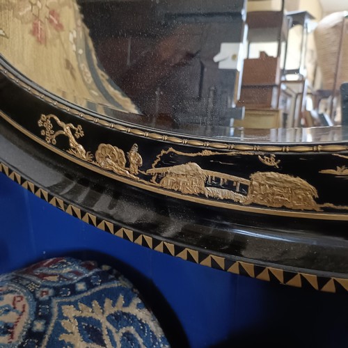 863 - An oval mirror, decorated in the Chinese manner, 90 x 65 cm