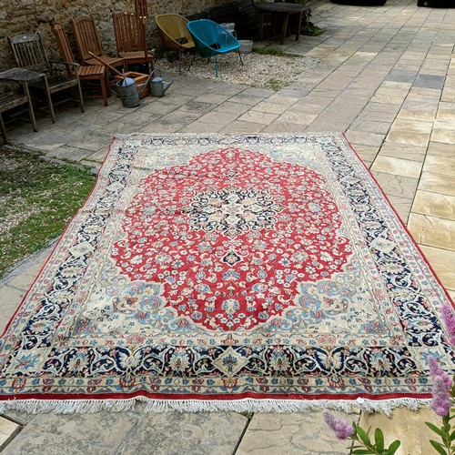 870 - A red ground Persian carpet, with a central blue cartouche, 370 x 257 cm