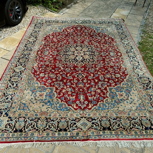 870 - A red ground Persian carpet, with a central blue cartouche, 370 x 257 cm