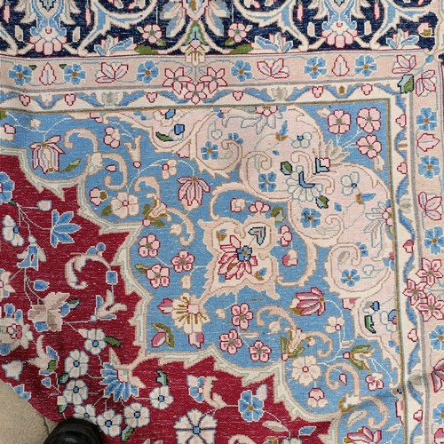 870 - A red ground Persian carpet, with a central blue cartouche, 370 x 257 cm