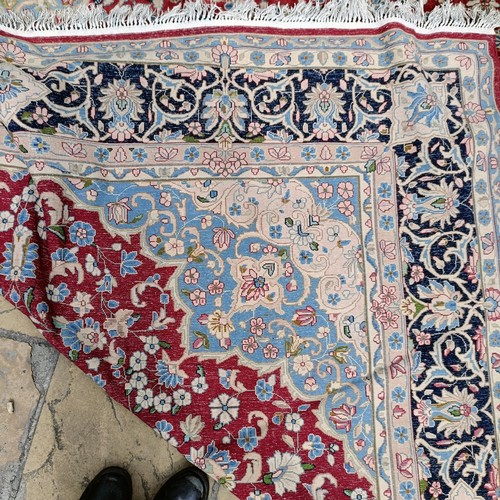 870 - A red ground Persian carpet, with a central blue cartouche, 370 x 257 cm