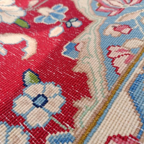 870 - A red ground Persian carpet, with a central blue cartouche, 370 x 257 cm