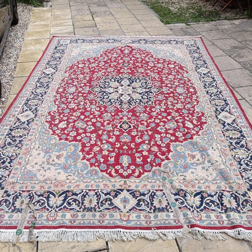 870 - A red ground Persian carpet, with a central blue cartouche, 370 x 257 cm