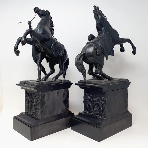 553 - A pair of Marley type horses, on polished slate bases, 45 cm high (2)