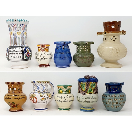 561 - A majolica style puzzle jug, 16 cm high, and assorted other puzzle jugs (box)