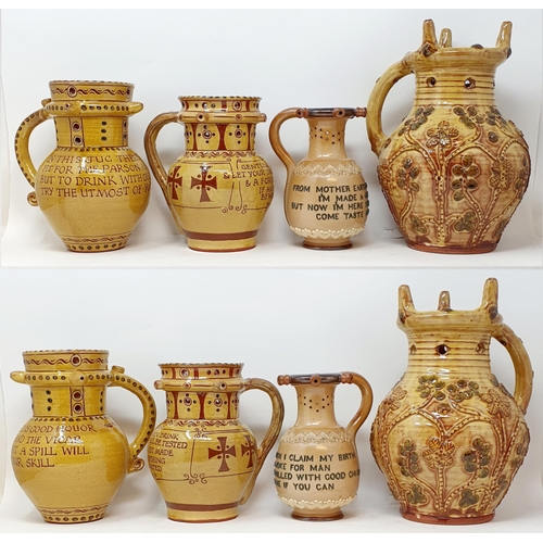 568 - A Royal Doulton puzzle jug, with a motto, 18 cm high, and three other slip glazed puzzle jugs (4)