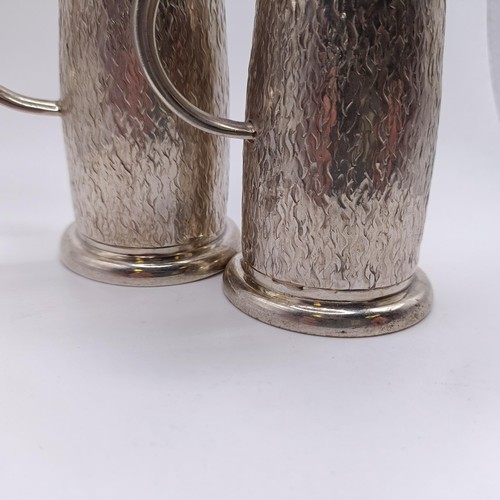 98 - A pair of modernist chased silver pepperettes, of good gauge and slender baluster form, London 2002,... 